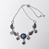 Silver ankletwith heart and eye-shaped charms on a white background