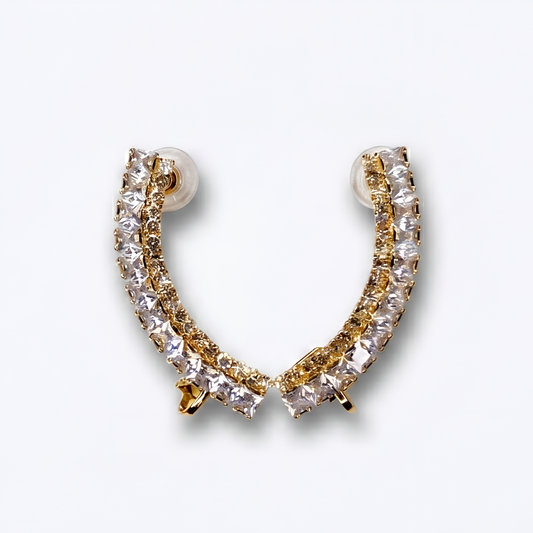 Gold and clear crystal hoop earring on a light gray background