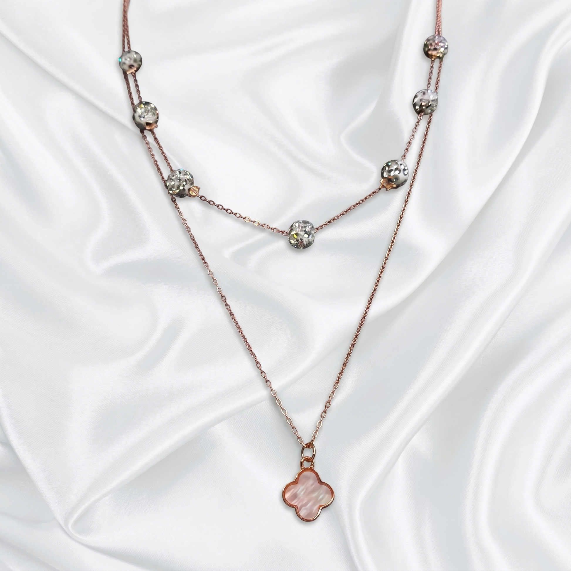 Necklace with floral pendant on a white satin background