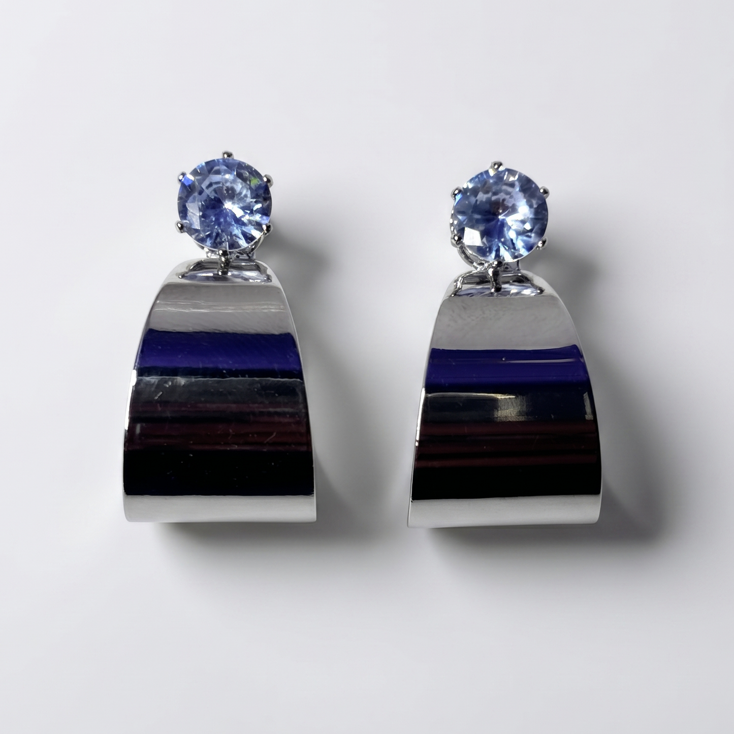 Pair of earrings with blue gemstones on a white background