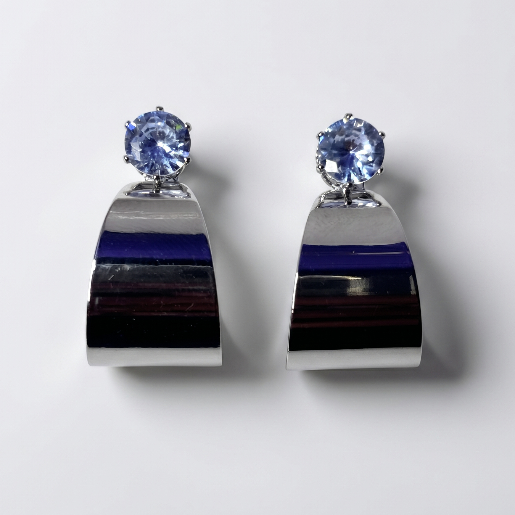 Pair of earrings with blue gemstones on a white background