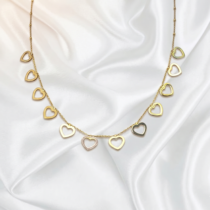 Gold heart-shaped necklace on a white satin background