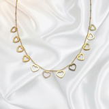 Gold heart-shaped necklace on a white satin background
