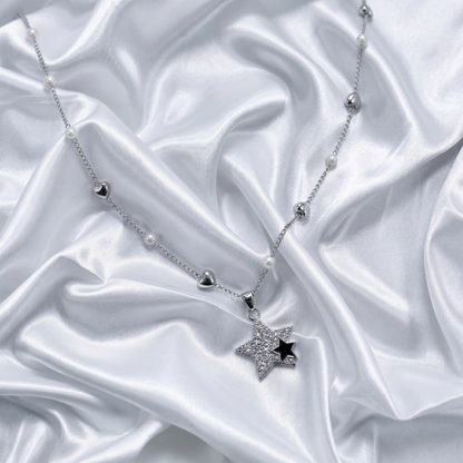 Silver necklace with a star pendant on a white satin background