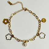 Gold bracelet with flower-shaped charms on a light gray background