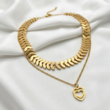 Gold necklace with a heart pendant on a white fabric background
