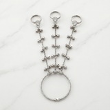Silver beaded hand chain on a white background