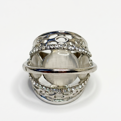 Silver ring with intricate design on a white background