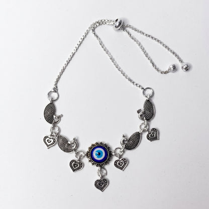 Silver ankletwith heart and eye-shaped charms on a white background