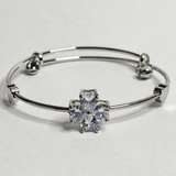 Silver bangle with a star-shaped crystal on a light gray background