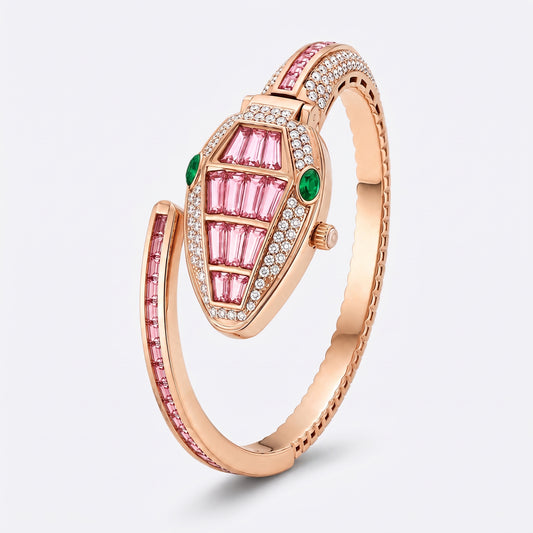 A rose gold snake-shaped bangle ring featuring pink and green stones, set with small clear crystals, on a light gray background.