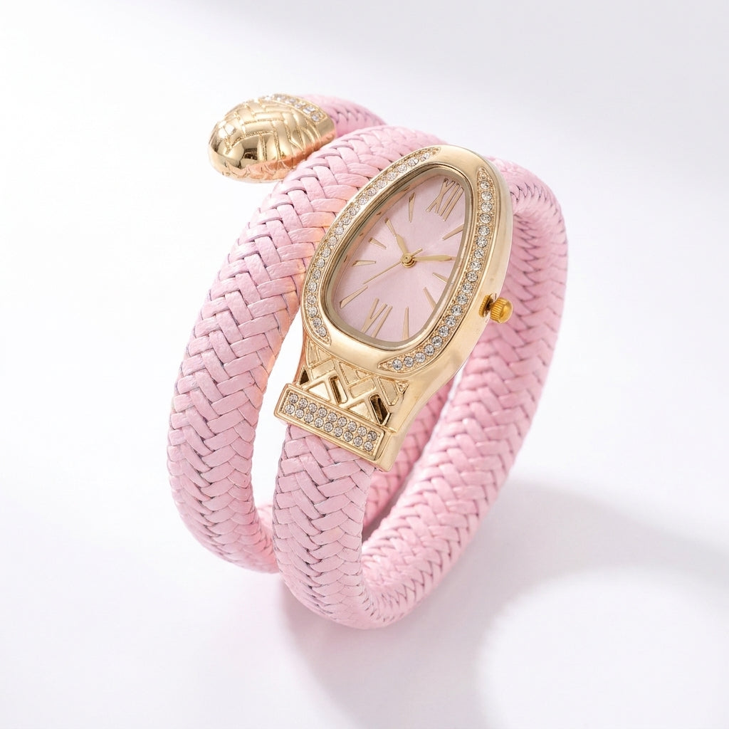 A pink braided wrap bracelet watch with a gold-tone case, crystal-embellished bezel, and a matching pink dial, shown on a clean white background.