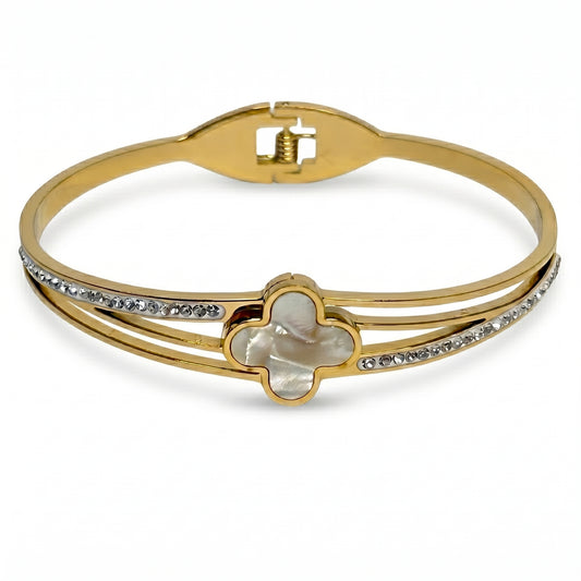 Gold bracelet with clover design and clear stones on a white background