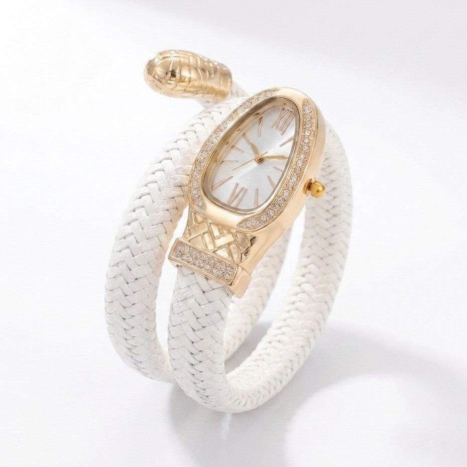 A luxury wrap bracelet watch featuring a white braided leather strap, a gold-toned oval case accented with pavé crystals, and a white dial with gold Roman numerals.