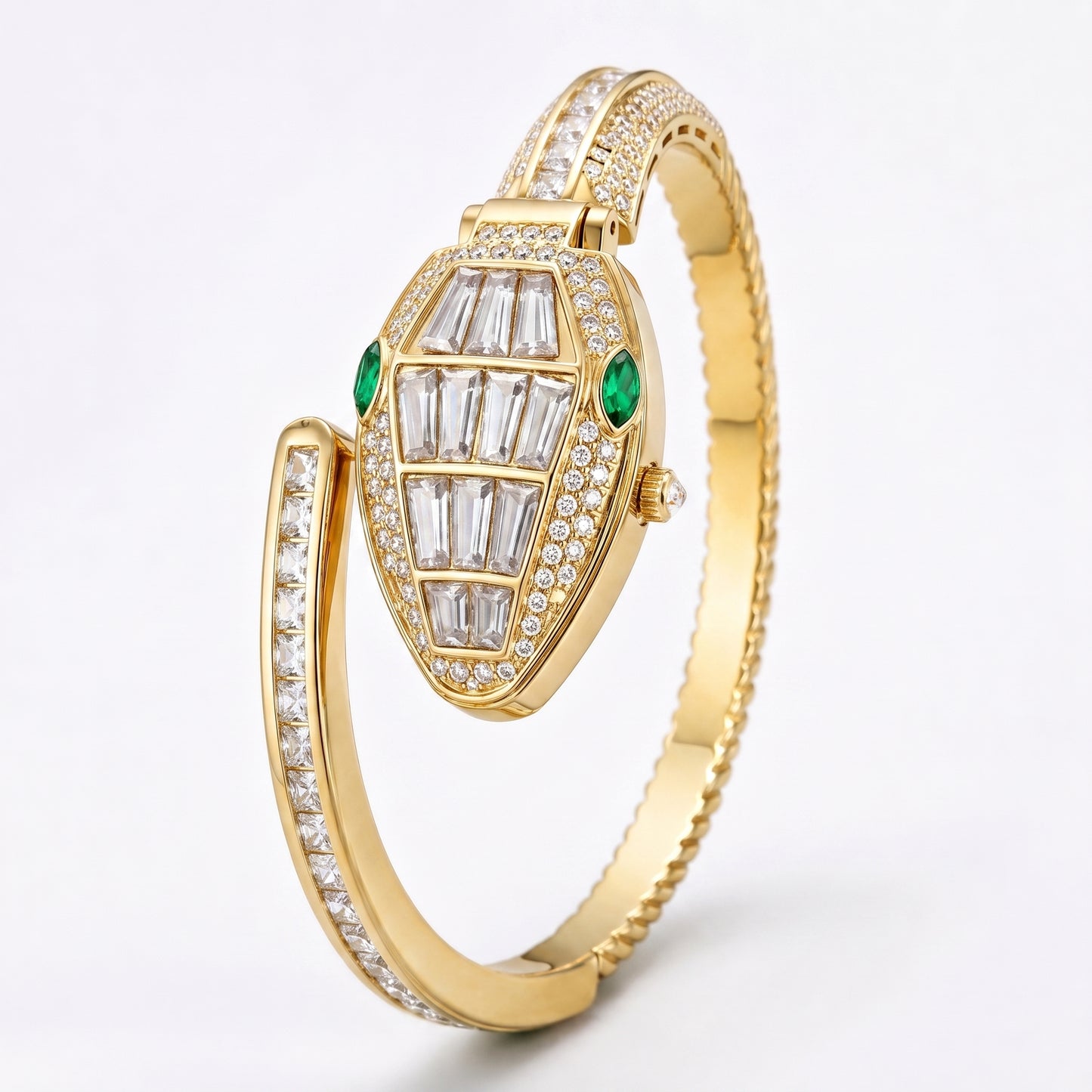 A gold hinged bangle watch featuring a snake-head dial paved with clear baguette and round diamonds, accented by two green emerald-cut gemstones, set against a clean white background.